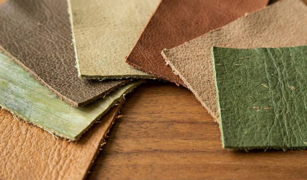 Shopper inspecting texture of cactus leather jacket in California boutique.